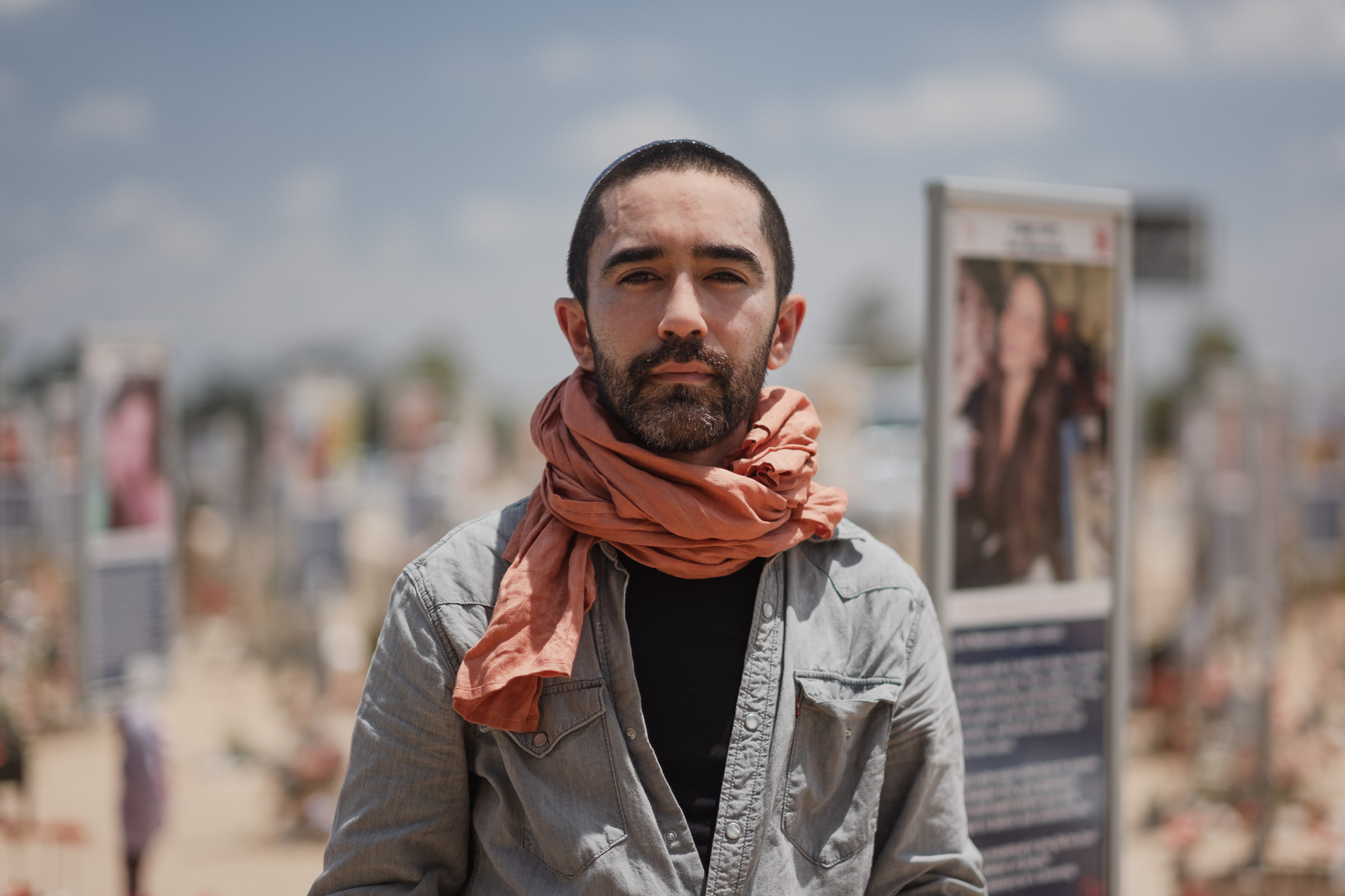 Levi Meir Clancy standing outdoors before an installation of public photographs